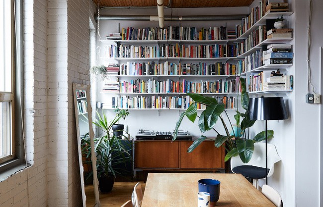 Phòng khách trong căn hộ được bố trí hết sức đơn giản. Tường được giữ nguyên gạch trần và sơn trắng. Thêm sofa đen phía dưới trở nên nổi bật. Không gian cũng trở nên cá tính và đặc biệt hơn với cách chọn lựa màu sắc cơ bản này.