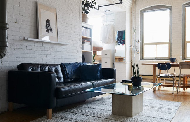 Góc tiếp khách còn được bố trí kệ sách vừa vặn với khoảng tường nhỏ giao giữa phòng khách với nơi nghỉ ngơi. Vợ chồng gia chủ đã chọn lựa kệ bằng gỗ sơn trắng, cùng tông màu với tường để giảm sự vướng víu khi nhìn tổng quan căn phòng.