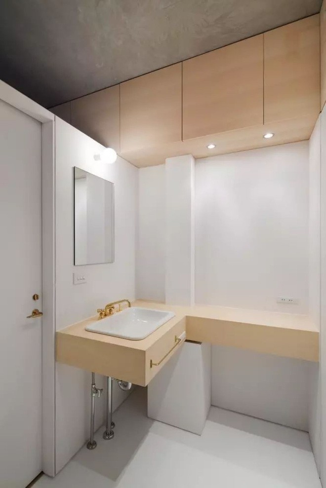 Không gian phòng tắm tách biệt với các căn phòng khác nhưng vẫn có sự kết nối về màu sắc. Vì gian phòng có diện tích khiêm tốn nên kiến trúc sư đã khéo léo sử dụng màu nền trắng để tăng độ sáng và rộng. Một vài chi tiết bằng gỗ giúp căn phòng thêm điểm nhấn giản dị và bình yên.