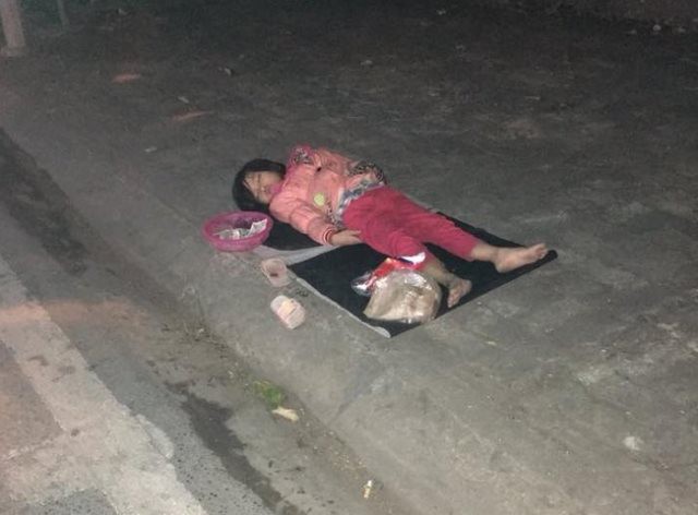 
Hình ảnh bé gái 5 tuổi nằm ngủ trên vỉa hè vì quá mệt khiến nhiều người xót xa.
