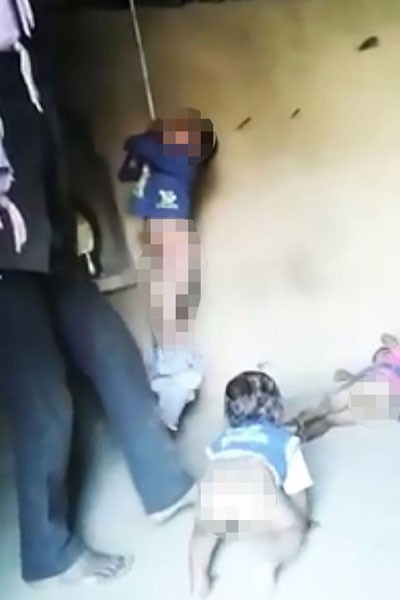 Hai đứa trẻ 5 và 3 tuổi bị bố đánh bằng roi trong khi đứa bé hơn bò giữa nền nhà. Ảnh: CEN
