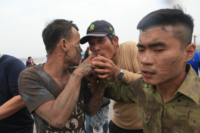 Mọi người cùng nhau chạm tay thậm chí hôn quả phết dù đầy bùn đất để lấy may.