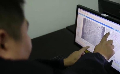 
Cảnh sát xem xét những dấu vân tay trên màn hình.
