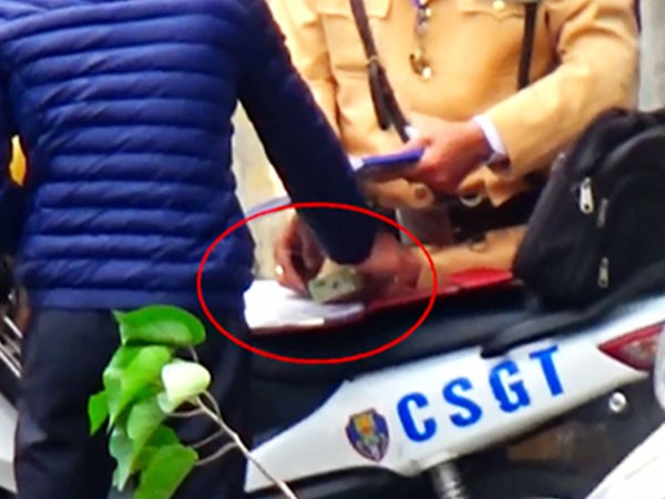 CSGT Hà Nội nhận một tờ nghi là tiền từ một người vi phạm giao thông - Ảnh cắt từ clip
