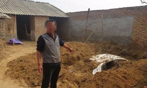 Người đ&agrave;n &ocirc;ng đ&agrave;o hố ch&ocirc;n chiếc xe ở s&acirc;n sau nh&agrave; để tr&aacute;nh sự truy t&igrave;m của cảnh s&aacute;t. Ảnh: South China Morning Post.
