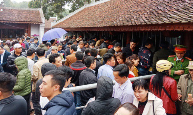 
Người dân đội mưa xếp hàng xin ấn sáng ngày 2-3 tại đền Trần. Ảnh: PV
