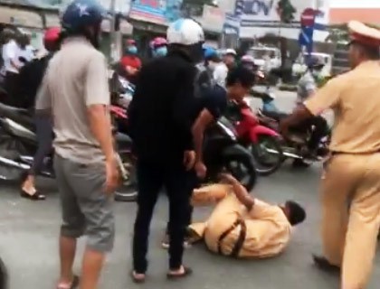 
Cảnh sát giao thông bị thanh niên quật ngã. Ảnh cắt từ clip.
