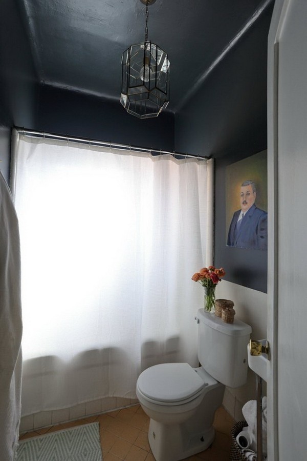 Cánh cửa cuối cùng chính là không gian nhà tắm nhỏ bé với màu đen mạnh mẽ của trần nhà, rèm cửa màu trắng giúp không gian phòng tắm vẫn có được sự riêng tư khi cần thiết. Tất nhiên, phòng tắm cũng được trang trí tỉ mẩn với bức họa hài hước và bình hoa đáng yêu.