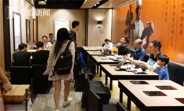 Người phụ nữ (đeo balo đen) mắng lại ch&agrave;ng trai (đang ngồi, đeo k&iacute;nh) v&igrave; bị anh n&agrave;y c&aacute;o buộc cho con t&egrave; v&agrave;o cốc uống tr&agrave;.