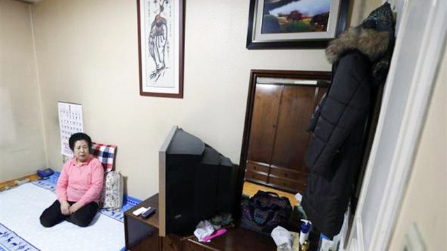 Bà Choi Gyeong Ja, sống đơn độc, đang ngồi xem TV trong căn hộ của bà ở Seocho-gu, gần khu nhà giàu Gangnam, ở Seoul vào ngày 16-1-2013 - Ảnh: REUTERS