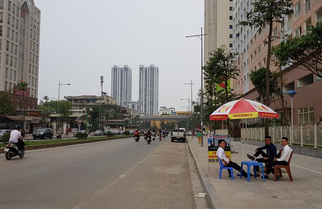 Nhân viên bán hàng của dự án Booyoung Vina Hà Đông tràn ra vỉa hè vẫn không chào mời được khách tham khảo căn hộ chung cư. Ảnh: PV