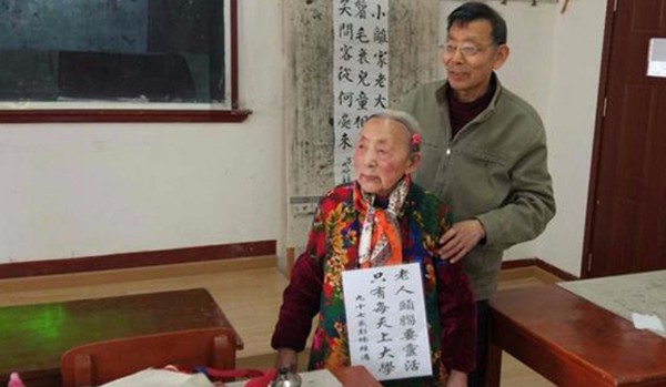 Cụ Peng Nan đeo tấm bảng trước cổ để khuyến kh&iacute;ch người gi&agrave; đi học như m&igrave;nh. Ảnh: SCMP