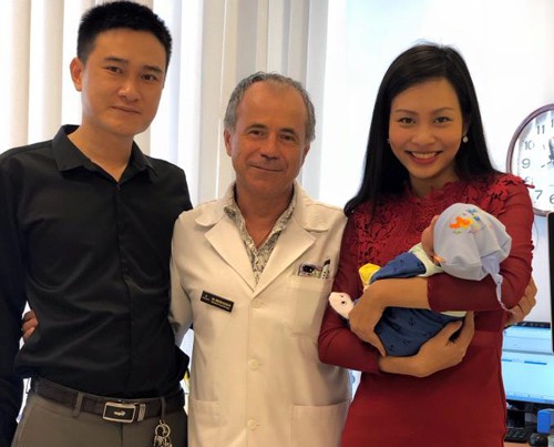 
Vợ chồng anh Tuấn chụp ảnh với bác sĩ người Pháp, một trong hai bác sĩ đã thực hiện phẫu thuật cứu em bé ngay trong bụng mẹ.
