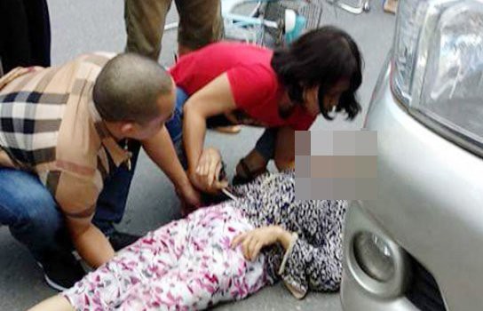 T&agrave;i xế Sơn v&agrave; người vợ (&aacute;o đỏ) xuống xe đỡ nạn nh&acirc;n đưa đi cấp cứu