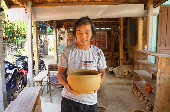Thợ giỏi Nguyễn Văn Xê khoe chiếc chậu được làm từ đất sét mới hoàn thành.