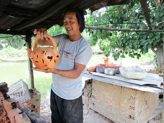 Thợ giỏi Xê bên một sản phẩm lồng đèn với vừa lấy trong lò nung ra.