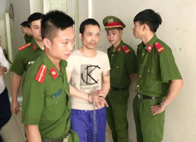 
Cảnh sát dẫn giải bị cáo Lê Văn Thọ vào phòng xử.
