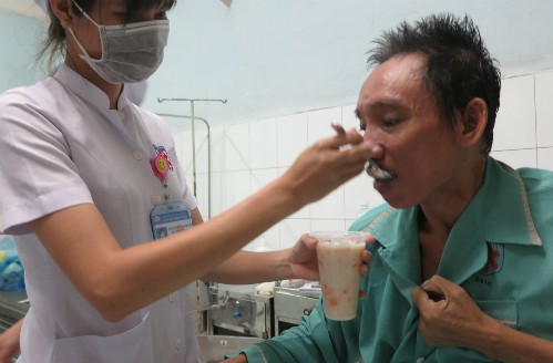Sau hơn hai tuần được bệnh viện chăm sóc, ông Cảnh đã có thể ngồi dậy, tự xúc ăn. Ảnh: Phan Thân.
