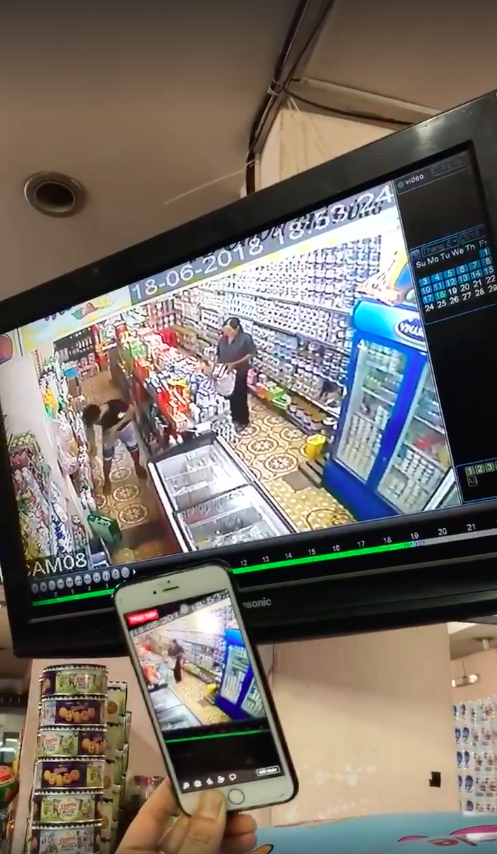 
Camera ghi lại hình ảnh người phụ trộm sữa hộp cho vào bao tải. Ảnh cắt từ clip.
