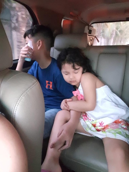 Khi di chuyển đến các địa điểm vui chơi, bé Na ngủ gật trên xe nhưng vẫn ôm chặt anh trai.