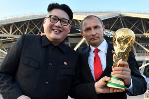 Bản sao của Kim Jong-un, Putin cầm cúp vàng ngoài sân vận động. Ảnh: AFP