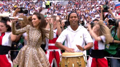 Cựu cầu thủ Brazil - Ronaldinho (áo trắng) - hào hứng đánh trống bên dàn vũ công Nga. Trước đó, đồng hương của anh - Ronaldo - cũng xuất hiện ở lễ khai mạc.