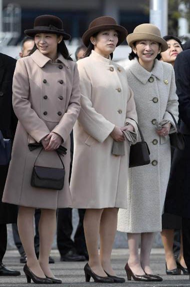 Công chúa Kako cùng chị và mẹ (phải) - công nương Kiko - ra sân bay tiễn Nhà vua Akihito và Hoàng hậu Michiko, khi hai người sang thăm Việt Nam năm 2017. Ba mẹ con đồng điệu về phong cách, với áo dạ cùng giày, mũ tông màu trầm. Công nương Kiko có ba người con, hoàng tử út chào đời năm 2006. Công nương luôn xuất hiện với phong thái thích hợp với hoàng tộc, cách cư xử kín đáo và đúng lễ nghi . Ảnh: Sankei.