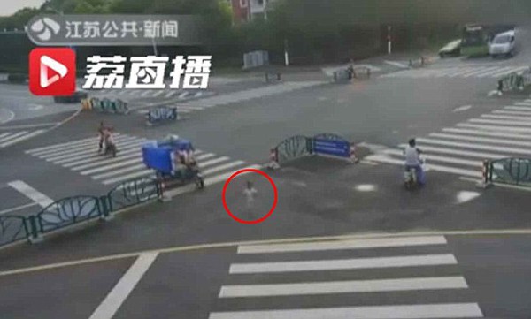 Cậu bé 5 tuổi một mình lang thang trên đường. Ảnh: Jiangsu TV.