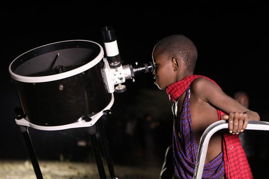 Một em b&eacute; Kenya xem trăng qua k&iacute;nh thi&ecirc;n văn - ảnh: Daniel Irungu/EPA