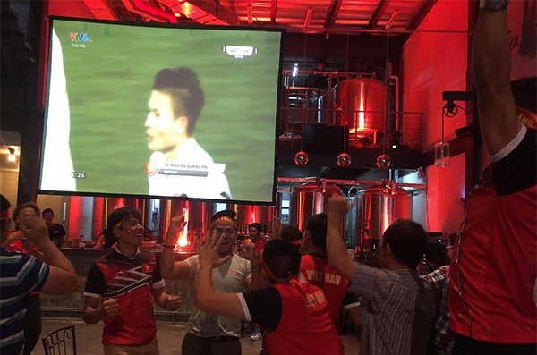 
CĐV trong một quán bar ở TP HCM nhảy cẫng lên mừng vui vì bàn gỡ của Quang Hải. Ảnh: VnExpress.
