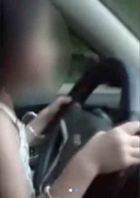 Bé gái 6 tuổi ngồi trên đùi mẹ lái xe ở Hàm Ninh, Trung Quốc, hôm 14/8. Ảnh cắt từ video.