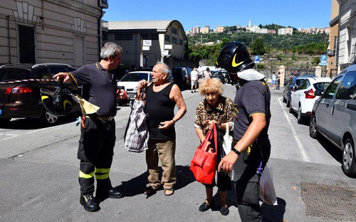 Một đôi vợ chồng lớn tuổi trò chuyện với lực lượng cứu hộ tại Genoa hôm 15/8, khi đang đợi vào nhà để lấy đồ. Ảnh: AFP.