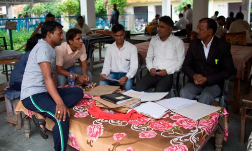Các nhân viên của Jan Sahas ngồi bên ngoài một tòa án địa phương ở Bharatpur phân tích hồ sơ vụ kiện với luật sư Pohiya. Ảnh: CNN.