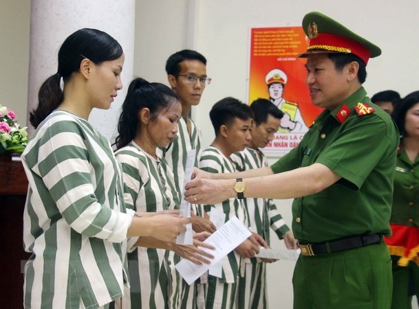 Đại tá Nguyễn Văn Viện, Phó giám đốc Công an TP Hà Nội, trao quyết định của Tòa án nhân dân thành phố về việc tha tù trước thời hạn có điều kiện cho các phạm nhân.