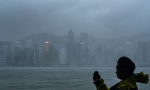 Người đàn ông đứng chụp ảnh tại Hong Kong khi bão Mangkhut đổ bộ vào hôm qua. Ảnh: AFP.