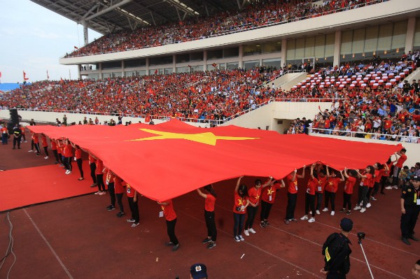 Lá quốc kỳ lớn được các tình nguyện viên căng ra dưới sân vận động