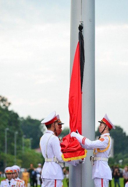 
Quốc kỳ được các chiến sĩ buộc thêm dải băng đen. Ảnh: Cao Tuân
