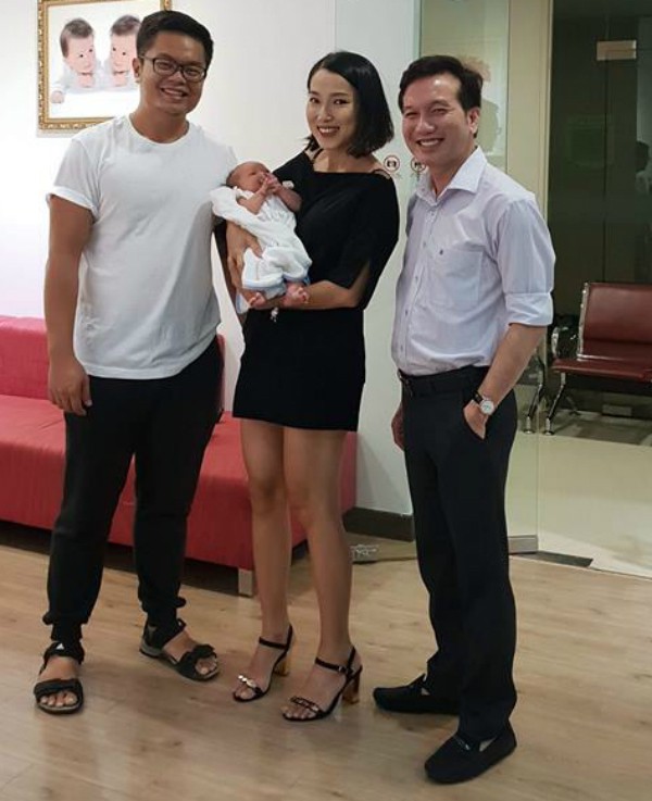 Quỳnh Giang cạnh chồng (bên trái) và bác sĩ Lê Văn Hiền sau 20 ngày sinh con. Ảnh: Q.G