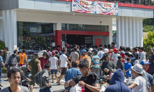 Người dân lấy hàng hóa trong một cửa hàng tiện lợi ở Palu ngày 30/9. Ảnh: AFP