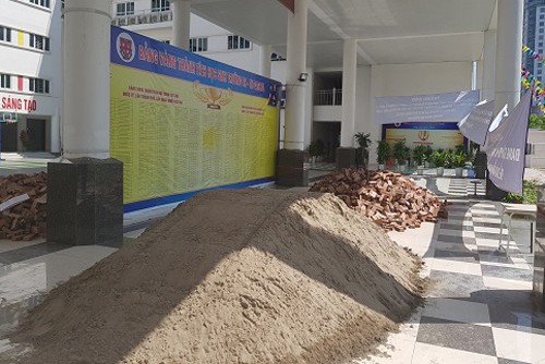 Gạch, cát được đổ tại sảnh A trong khuôn viên trường. Ảnh: Gia Chính