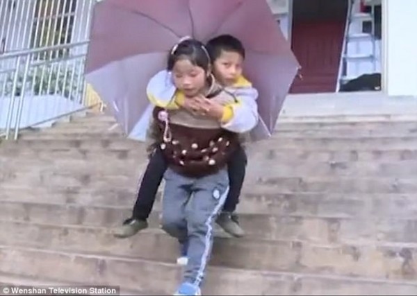 Cô bé Dingshuang, 9 tuổi, không quản ngại khó khăn đều đặn cõng anh đến trường mỗi ngày.
