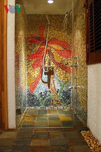 Kết hợp nhiều loại vật liệu: Tường khoang tắm đứng ốp gạch mosaic gốm thành bức tranh, khu vực khác được sơn, sàn lát đá slate và rải sỏi; tạo nên sự sang trọng mà vẫn gần gũi.