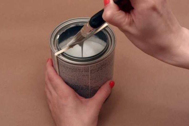 Buộc dây chun vào miệng hộp sơn và đó sẽ là nơi để bạn gạt những giọt sơn thừa bám trên chổi cọ.