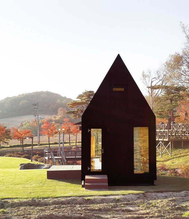 Kính và gỗ tối màu định hình cabin nhỏ với thiết kế thân thiện với môi trường