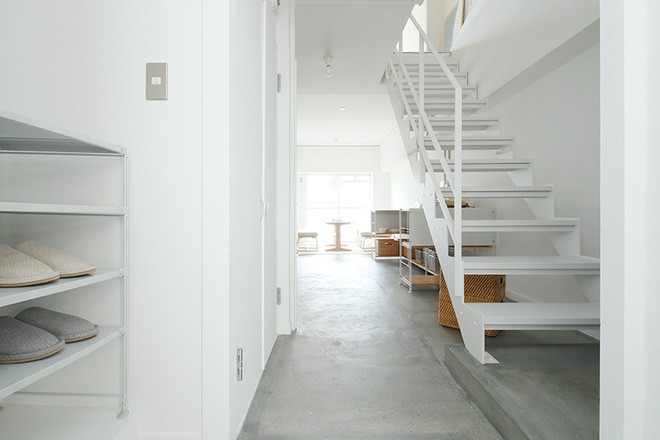 Lối vào nhà được gia chủ bố trí kệ đựng giày dép, vị trí đặt cầu thang lên xuống và hệ thống tủ đựng đồ ăm tường. Còn lại là lối đi và tạo sự thoáng đãng cho không gian.