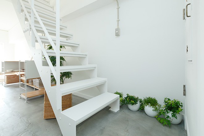 Cầu thang lên tầng 2 được thiết kế cùng tông màu với tường, thêm những chậu hoa để căn phòng thêm ấn tượng.