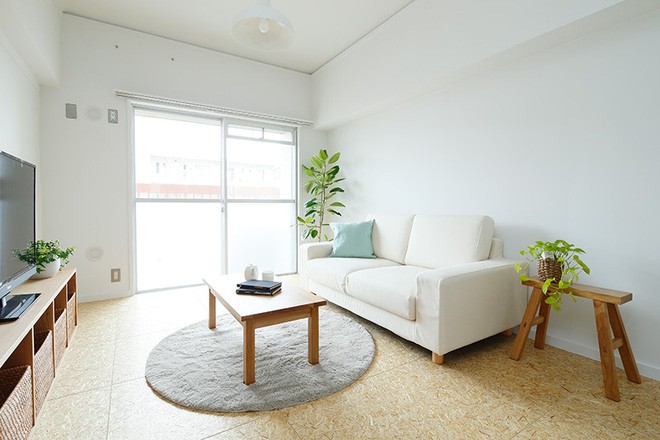 Màu trắng của trần và tường giúp mở rộng diện tích. Sofa màu be giúp kết nói màu gỗ của kệ đừng đồ, màu đất của sàn và màu ghi của thảm trải sàn. Chút nhấn nhá từ những cây cảnh tự nhiên cho góc nhỏ thêm yên bình và trong lành.