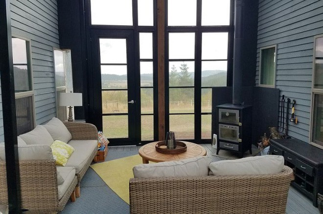 Ngay phía dưới của lớp màn kính trong suốt đó, chủ nhân đã khéo léo bố trí một không gian phòng khách nhỏ đủ để tiếp đón bạn bè của mình. Với bộ sofa đơn giản, nhưng hiệu ứng từ những ánh sáng chiếu xuống màn kính trong suốt ngày và đêm đã làm cho phòng khách trông đặc biệt.