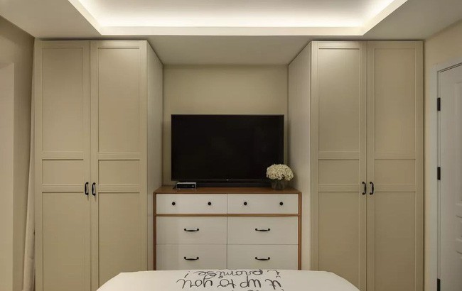 Bức tường đối diện giường cũng được tận dụng triệt để, tủ quần áo đủ để chứa quần áo cho 2 người sống trong nhà. Ưu điểm của việc mở tủ quần áo là nó có tính thẩm mỹ đối xứng và có thể làm cho chức năng tiện ích rõ ràng hơn. Ở giữa tủ quần áo là TV và tủ có ngăn kéo. TV được đặt trực tiếp trên tủ ngăn kéo và có thể nhìn thấy trên giường.