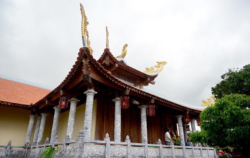 Bên hông nhà thờ chính với chóp ngói nhiều cặp rồng chầu. Những hàng cột chạy dọc hành lang bằng đá điêu khắc hình búp sen. Ảnh: Zing.